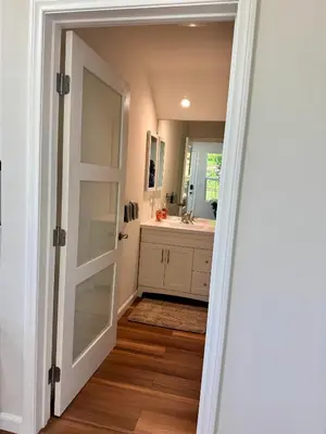 a bathroom with a door leading to a sink at Skylight Terrace in Los Angeles