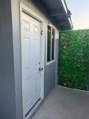 a door to a house with a green hedge at Asian Food Gallery mini back room in San Gabriel