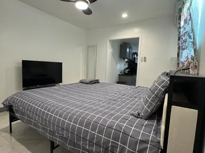 a bedroom with a bed and a flat screen tv at Asian Food Gallery mini back room in San Gabriel
