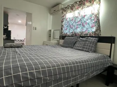 a bedroom with a bed with a plaid blanket at Asian Food Gallery mini back room in San Gabriel