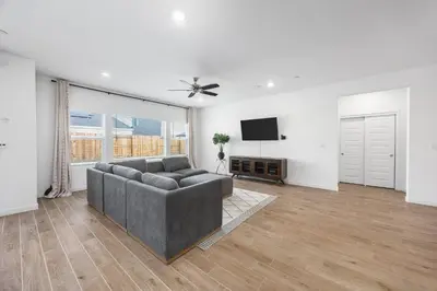 a living room with a couch and a flat screen tv at Serenity House- Newly Built, Peaceful Stay in Bakersfield