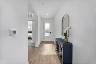 a hallway with a blue table and a mirror at Serenity House- Newly Built, Peaceful Stay in Bakersfield