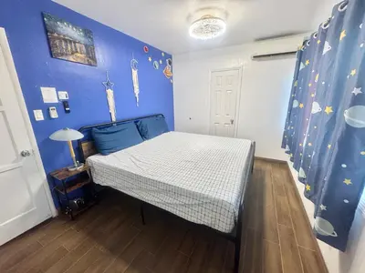 a bedroom with a bed with a blue wall at Asian Food Galler Single house in San Gabriel