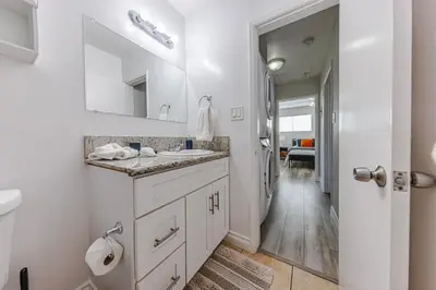 a white bathroom with a sink and a mirror at Spacious 2-Bedroom Duplex in Beverly Hills Residential Area in Los Angeles