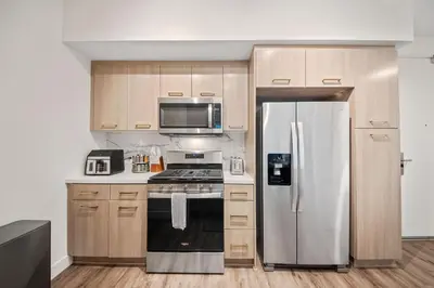 a kitchen with a stainless steel refrigerator and a stove at Casa Blanca Coastal Condo Rooftop Heated Pool in Los Angeles