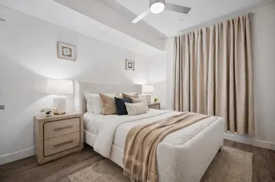 a white bedroom with a bed with a nightstand and a window at Casa Blanca Coastal Condo Rooftop Heated Pool in Los Angeles
