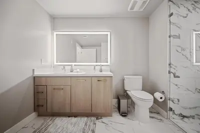 a bathroom with a sink and a toilet and a mirror at Casa Blanca Coastal Condo Rooftop Heated Pool in Los Angeles