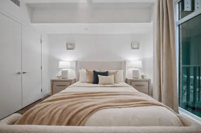 a white bedroom with a large bed with two night stands at Casa Blanca Coastal Condo Rooftop Heated Pool in Los Angeles
