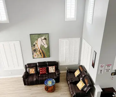 a living room with two leather couches and an umbrella at 3000sqft Modern Minimal 5BR3BA Home Near ONT in Ontario