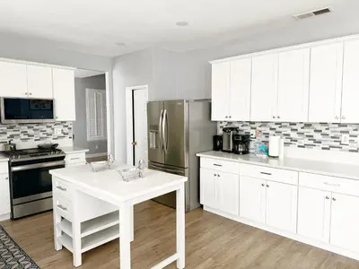 a kitchen with white cabinets and a stainless steel refrigerator at 3000sqft Modern Minimal 5BR3BA Home Near ONT in Ontario
