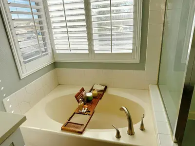 a bathroom with a tub with a sink and a window at 3000sqft Modern Minimal 5BR3BA Home Near ONT in Ontario