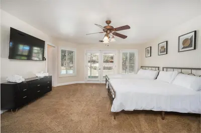 a bedroom with a bed and a ceiling fan at Your Poolside Hideaway in Bakersfield