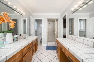 a bathroom with two sinks and a shower at Your Poolside Hideaway in Bakersfield