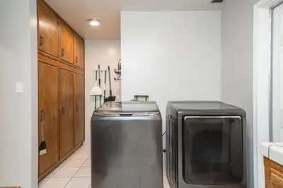 a kitchen with a dishwasher and a television in it at Your Poolside Hideaway in Bakersfield