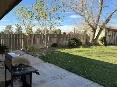 a grill in a yard next to a fence at Desert Ranch Retreat in Lancaster