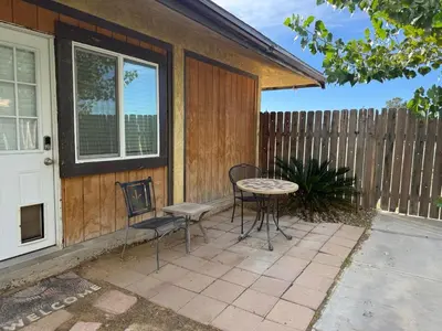 a patio with a table and chairs and a fence at Desert Ranch Retreat in Lancaster