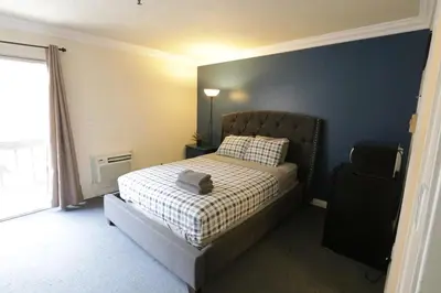 a bedroom with a bed and a blue wall at Beverly Hills Queen Bed Studio in Los Angeles