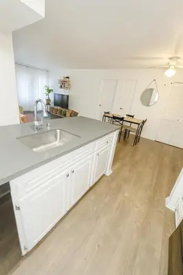 a white kitchen with a sink and a table at Hollywood Hills Haven - Resort Living Near Universal Studios & Warner Bros in Los Angeles