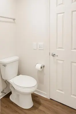 a white bathroom with a toilet and a door at Hollywood Hills Haven - Resort Living Near Universal Studios & Warner Bros in Los Angeles