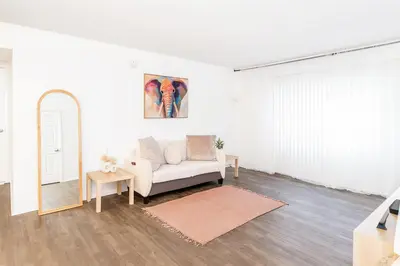 a living room with a white couch and a mirror at Hollywood Hills Haven - Resort Living Near Universal Studios & Warner Bros in Los Angeles