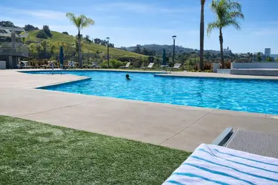 a large swimming pool with a person in the water at Hollywood Hills Haven - Resort Living Near Universal Studios & Warner Bros in Los Angeles