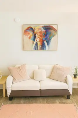 a living room with a white couch and a painting of an elephant at Hollywood Hills Haven - Resort Living Near Universal Studios & Warner Bros in Los Angeles