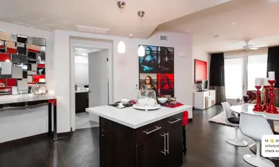 a kitchen and living room with a island in the middle at Modern 2BR at the Huxley Prime West Hollywood Location in Los Angeles