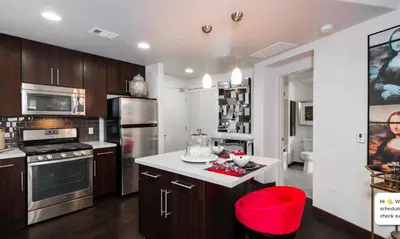 a kitchen with wooden cabinets and a white counter top at Modern 2BR at the Huxley Prime West Hollywood Location in Los Angeles