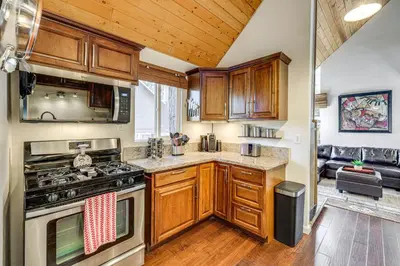 a kitchen with wooden cabinets and a stove top oven at 5 Mi to Mountain High Resort Home with Gaming Area in Wrightwood