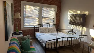 a bedroom with a bed and a brick wall at Studio Haven in the Heart of Hollywood in Los Angeles