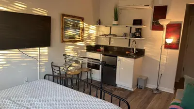 a small kitchen with a stove top oven next to a bed at Studio Haven in the Heart of Hollywood in Los Angeles