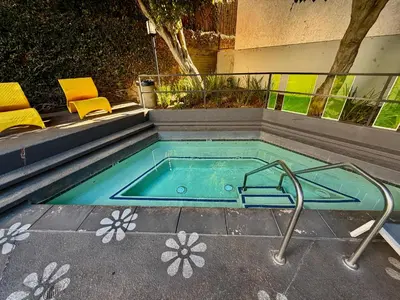 a pool with a hot tub with two chairs in it at Serene Stay with Pool Access & Balcony in Los Angeles