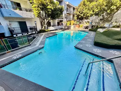 two blue swimming pools in a apartment complex at Serene Stay with Pool Access & Balcony in Los Angeles