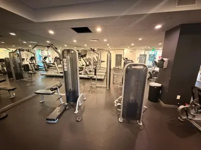 a gym with several treadmills and machines at Serene Stay with Pool Access & Balcony in Los Angeles