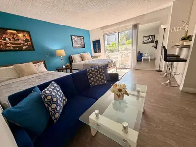 a living room with a blue couch and a table at Serene Stay with Pool Access & Balcony in Los Angeles