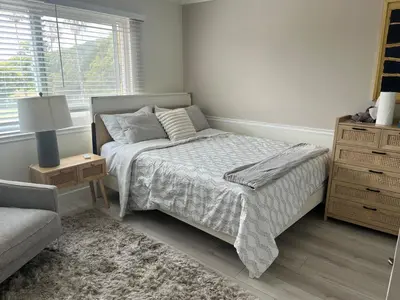 a bedroom with a bed and a couch and a window at Beach Sweet condo home in Los Angeles