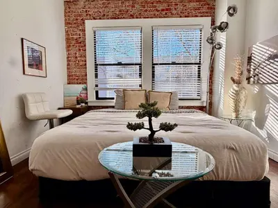 a bedroom with a bed and a table with a tree on it at Modern & Popular Hollywood Studio at GW in Los Angeles