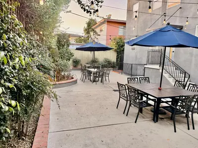a patio with tables and chairs with umbrellas at Charming Studio in the Heart of Hollywood in Los Angeles
