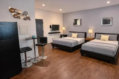 a hotel room with two beds and a television at Compact Hollywood Studio in Los Angeles