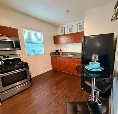 a kitchen with a black refrigerator and a table at Compact Hollywood Studio in Los Angeles