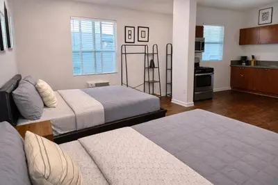 a living room with two beds and a kitchen at Compact Hollywood Studio in Los Angeles