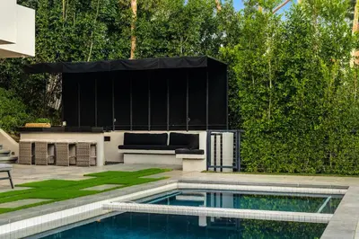 a swimming pool with a couch and a stage at Ultra Luxury 5BR Beverly Hills Estate with Private Pool Spa and Canyon Views in Los Angeles