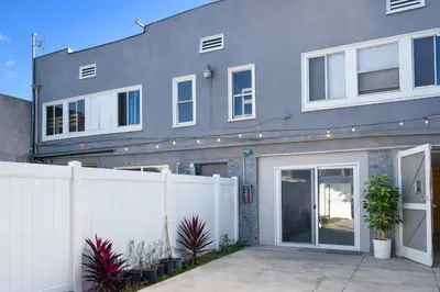 a house with a white fence in front of it at Vernon Homes For The Soul in Los Angeles