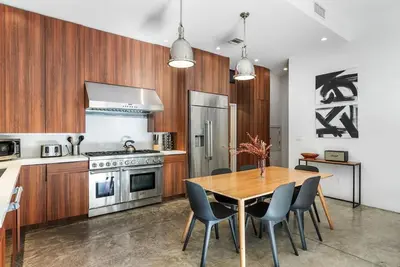 a kitchen with wooden cabinets and a wooden table and chairs at Vibrant SoCal Venice Beach Retreat in Los Angeles