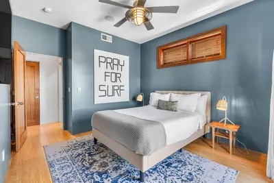 a bedroom with a bed and a blue wall at Vibrant SoCal Venice Beach Retreat in Los Angeles