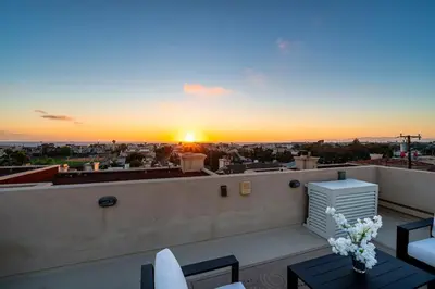 a sunset on a roof with a table and chairs at Phenomenal King, Air, Rooftop Deck, Walk to Beach in Hermosa Beach