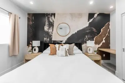 a bedroom with a large white bed and a wall at Modern 3BR Retreat with Rooftop Deck Sleeps 8 in Los Angeles