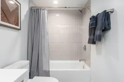 a bathroom with a tub and a toilet and a sink at Modern 3BR Retreat with Rooftop Deck Sleeps 8 in Los Angeles