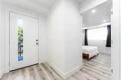a white room with a door and a bed at Modern 3BR Retreat with Rooftop Deck Sleeps 8 in Los Angeles