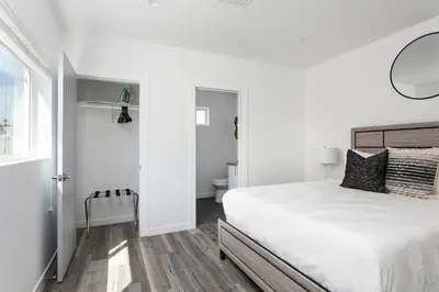 a white bedroom with a bed and a bathroom at Upscale 4BR Townhouse Sleeps 8 with Fast WiFi in Los Angeles